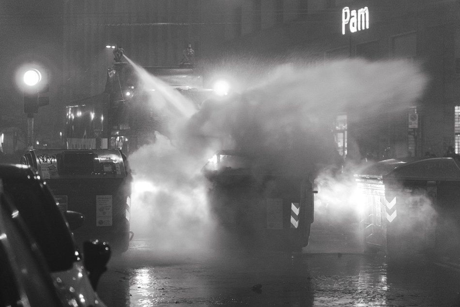 La polizia prova a spegnere un incendio